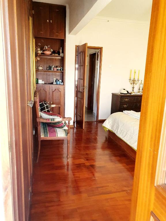 Un dormitorio con una cama y suelo de madera. en Guest House Amadora, en Amadora