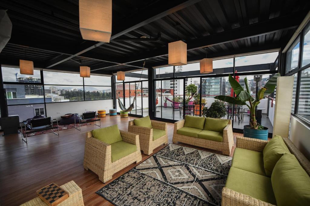 a living room with couches and chairs and windows at Casa Q in Quito