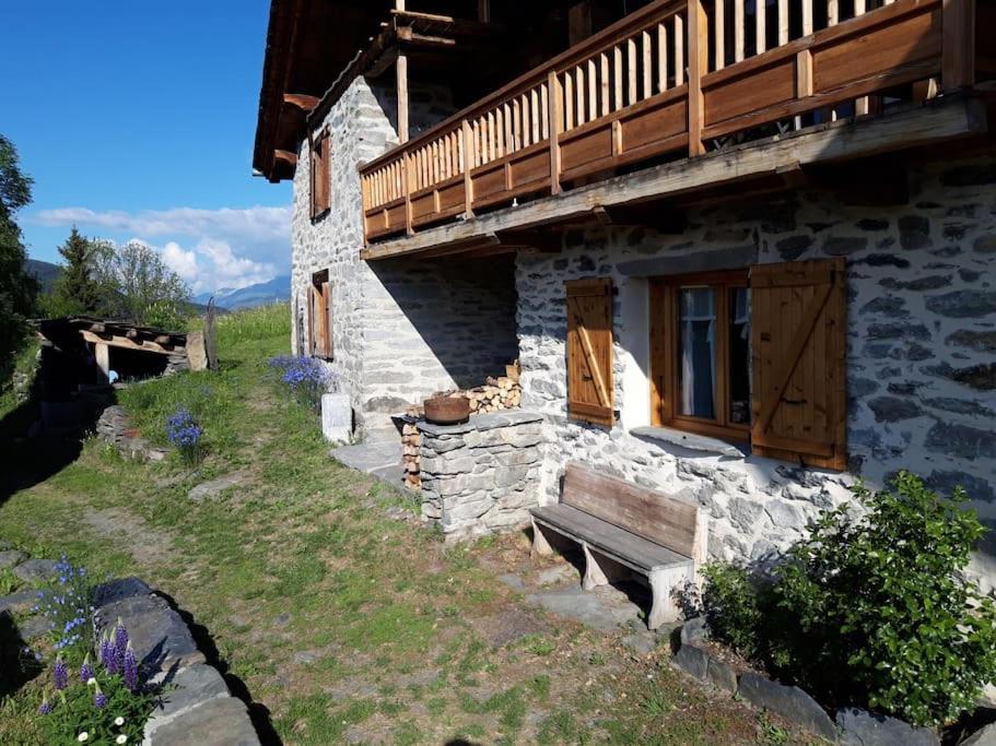 Cette maison en pierre dispose d'une terrasse couverte et d'un balcon. dans l'établissement Appartement dans chalet proche de la station de ski La Rosière San Bernardo, à Montvalezan