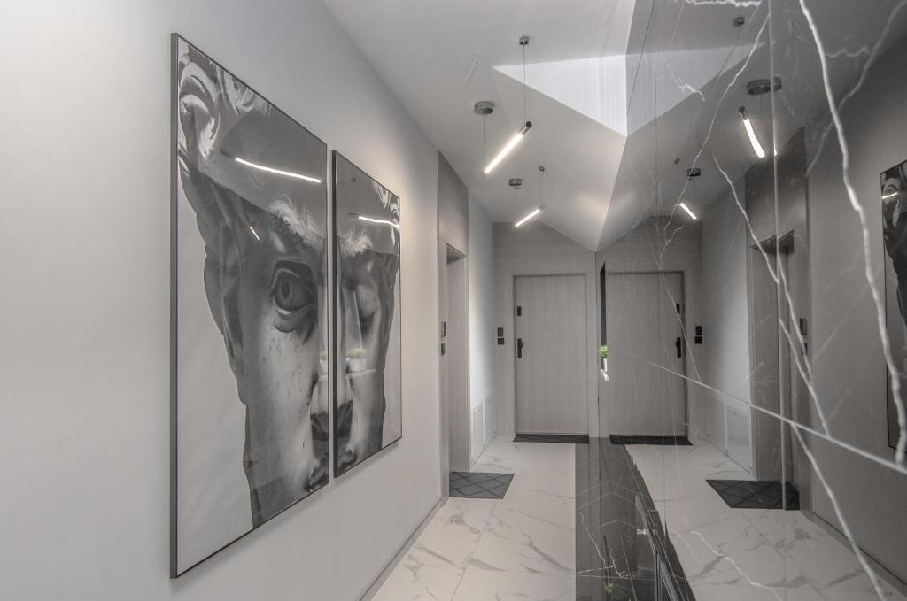 a hallway with black and white paintings on the walls at Austriacka Apartamenty 4 in Koszalin