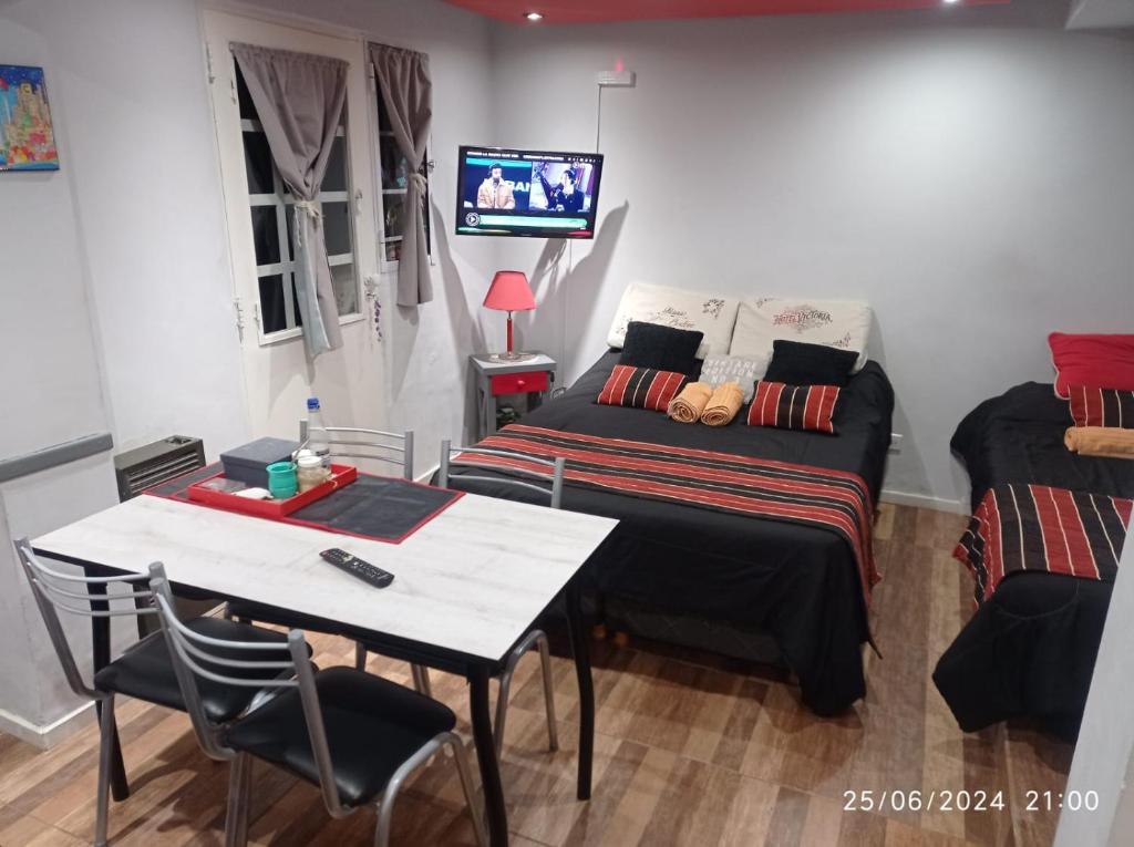 a room with a bed and a table and a tv at EnSueños Bariloche in San Carlos de Bariloche