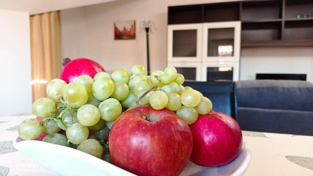 un tazón de manzanas y uvas sobre una mesa en Premium Sofy & Bea Home - 25 minuti da Roma Centro, en Albano Laziale