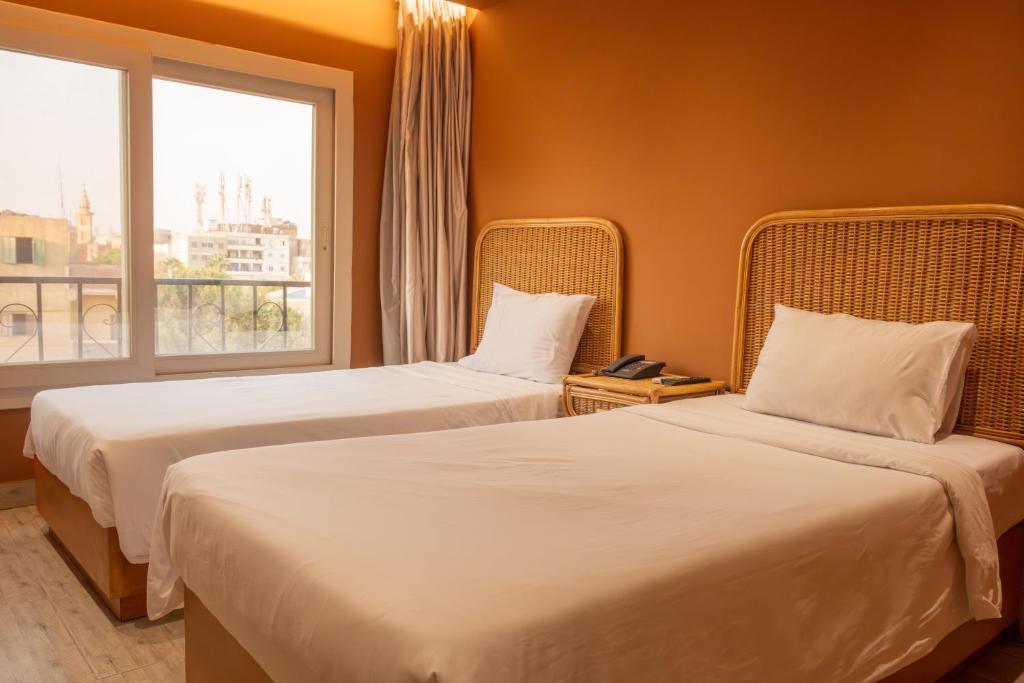 Postel nebo postele na pokoji v ubytování Jimmy Pyramids Hotel