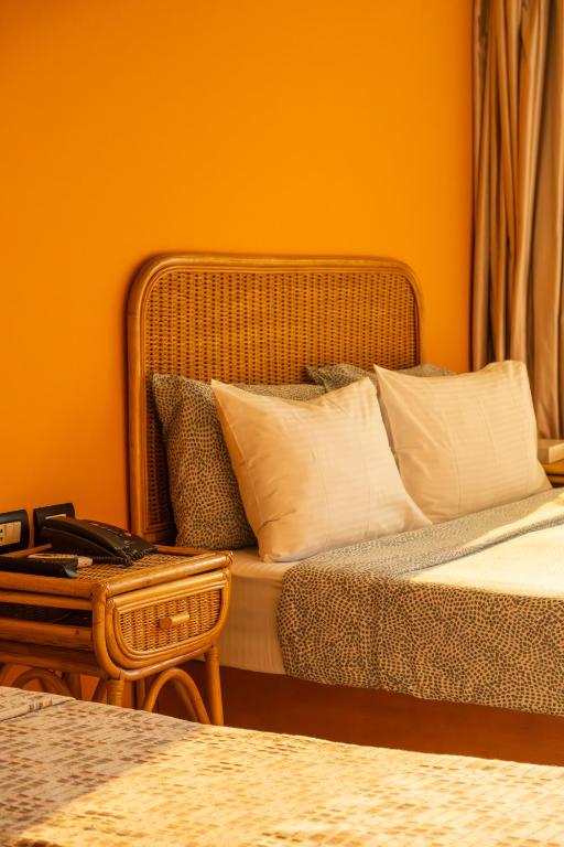 a bedroom with a bed with white pillows and a table at Jimmy Pyramids Hotel in Cairo