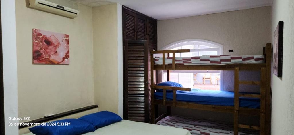 zwei Etagenbetten in einem Zimmer mit Fenster in der Unterkunft Casa do pé de Jabuticaba in Guarujá