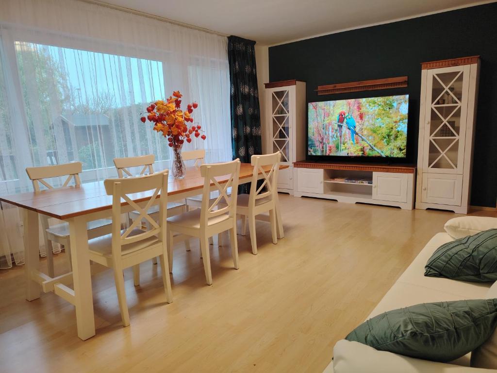 a dining room with a table and chairs and a television at Rhein Ferienwohnung 3-Zimmer Garten Free Parking Netflix Premium Disney Premium in Koblenz