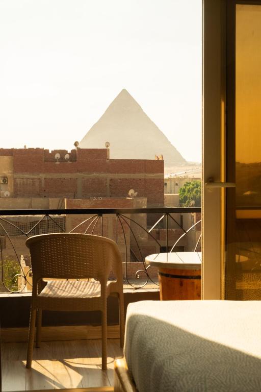 a room with a bed and a view of the pyramids at Jimmy Pyramids Hotel in Cairo