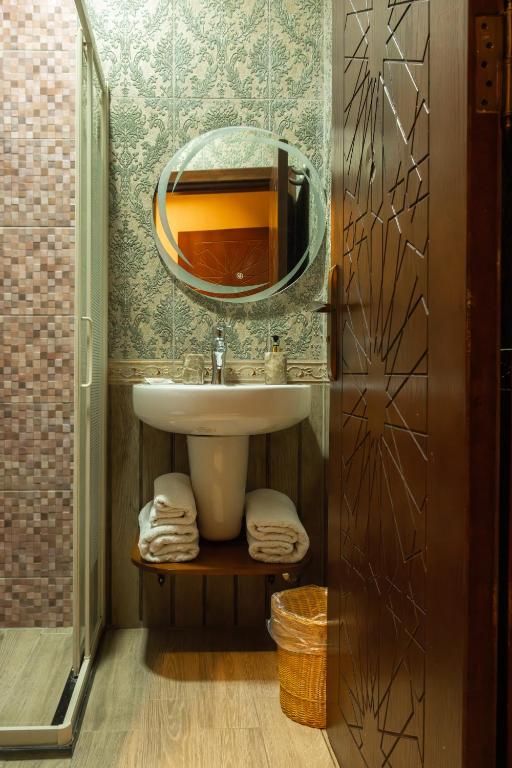 a bathroom with a sink and a mirror at Jimmy Pyramids Hotel in Cairo