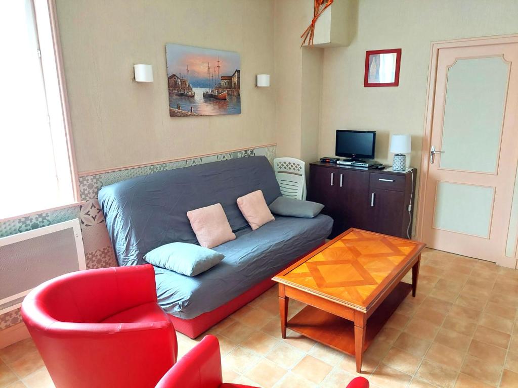 - un salon avec un canapé et un fauteuil rouge dans l'établissement Joli appartement 3 pièces au centre de Trouville, à Trouville-sur-Mer
