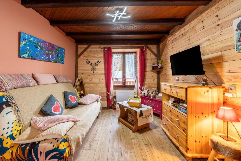a bedroom with a bed and a flat screen tv at Aux 4 saisons in Le Bouchet-Mont Charvin