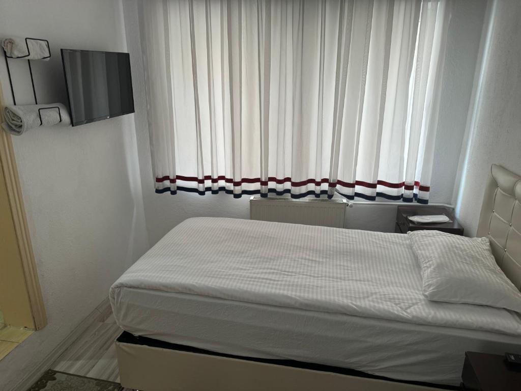 a small bedroom with a bed and a window at Gümüş Hotel in Ortahisar