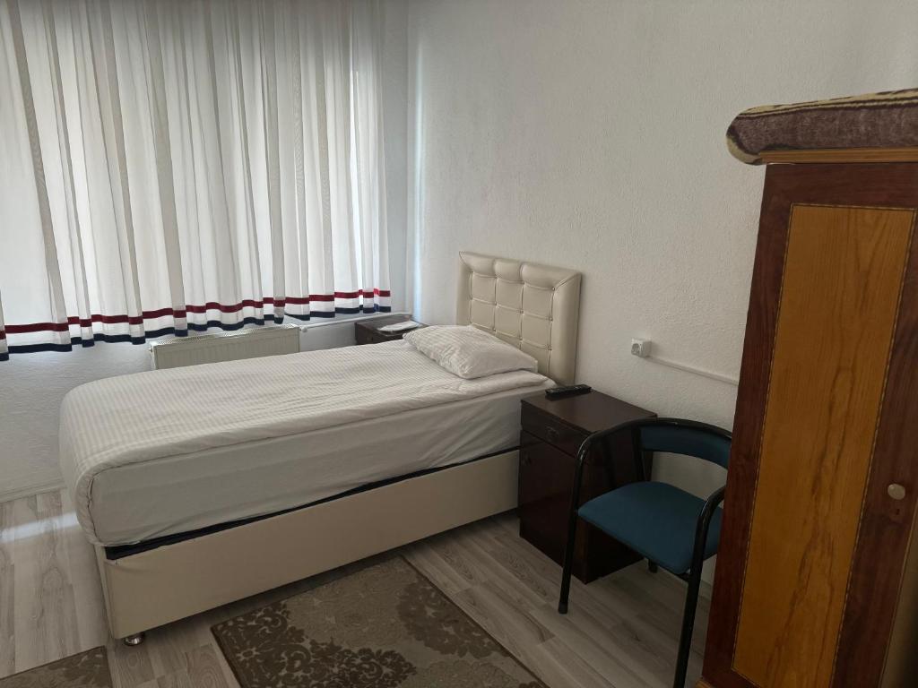 a bedroom with a bed and a desk and a chair at Gümüş Hotel in Ortahisar