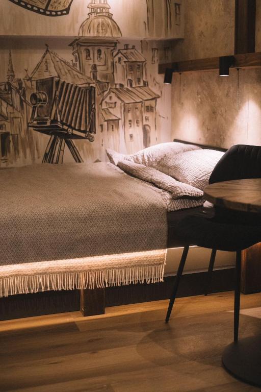 a bedroom with a bed with a drawing on the wall at Photographer Rudolf's Studio - ground floor with separate entrance in Rīga