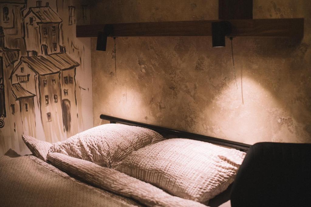 a bed with two pillows on top of it at Photographer Rudolf's Studio - ground floor with separate entrance in Rīga
