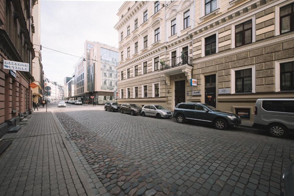 a city street with parked cars and buildings at Photographer Rudolf's Studio - ground floor with separate entrance in Rīga