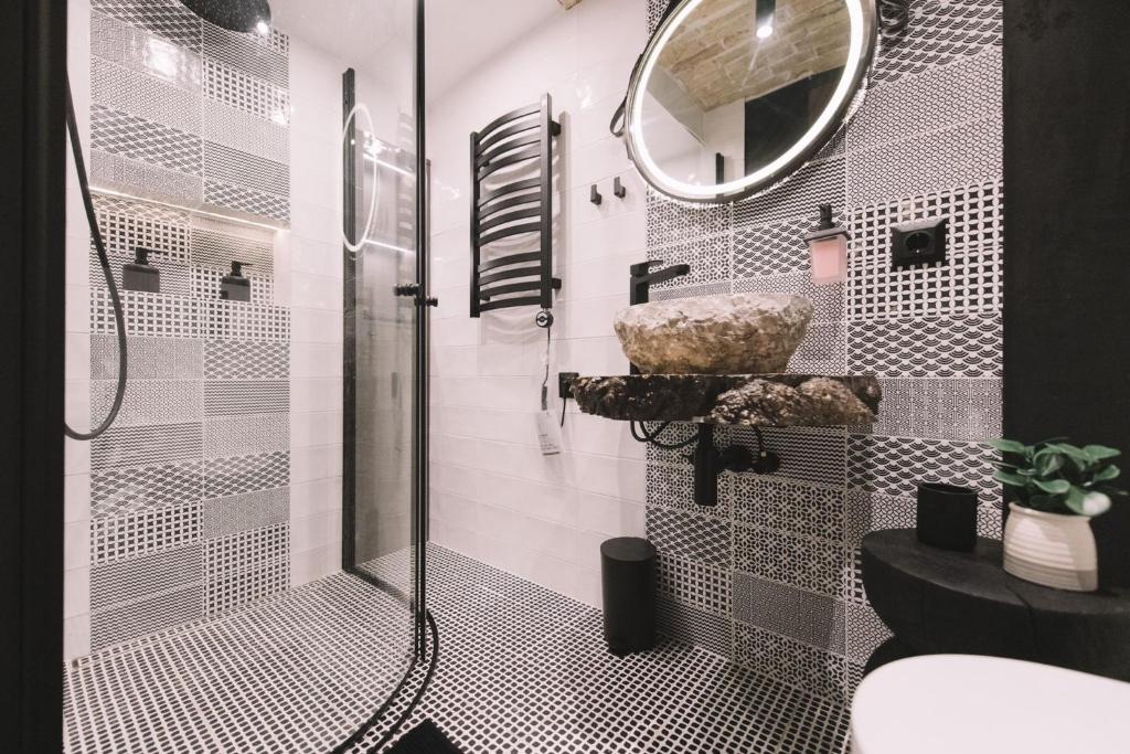 a bathroom with a shower with a sink and a mirror at Photographer Rudolf's Studio - ground floor with separate entrance in Rīga