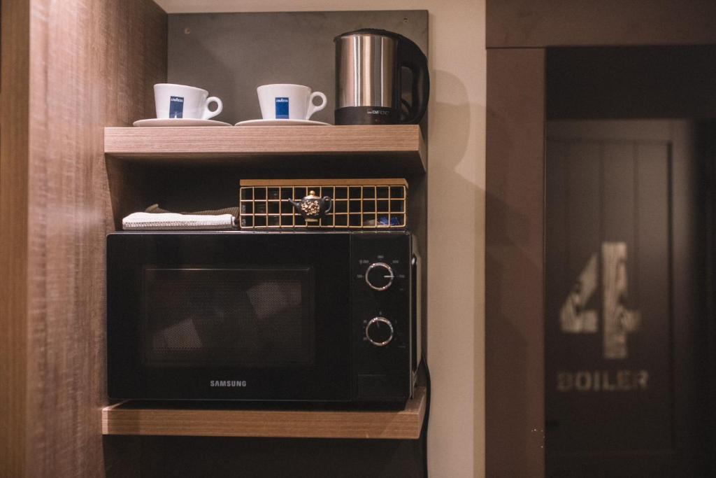 a microwave on a shelf in a room at Photographer Rudolf's Studio - ground floor with separate entrance in Rīga