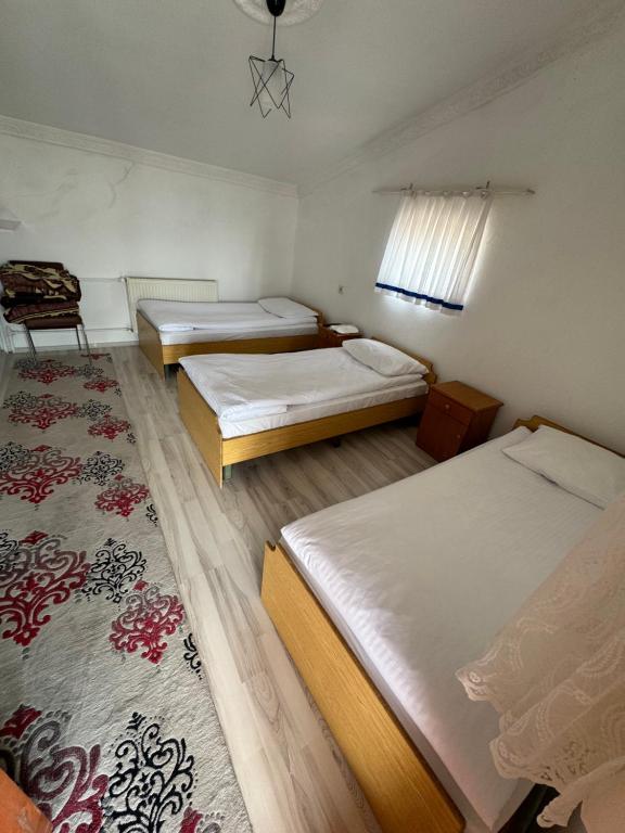 a room with two beds and a rug at Gümüş Hotel in Ortahisar