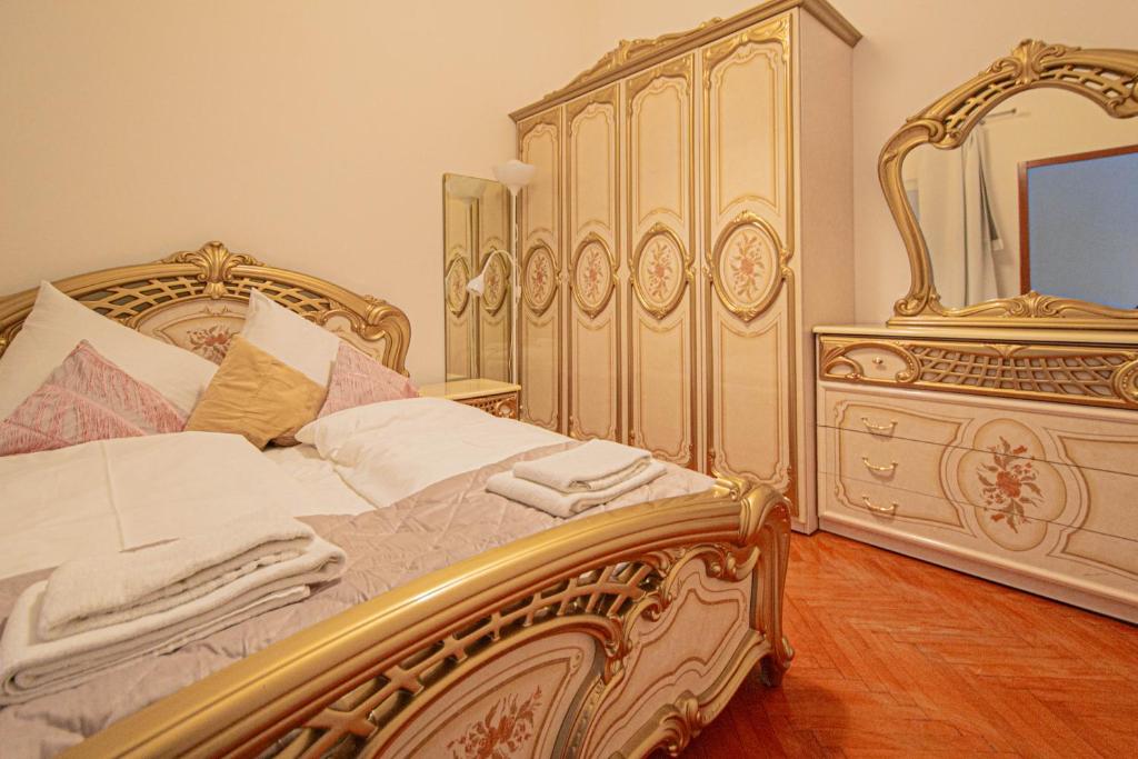 a bedroom with a bed and a dresser with a mirror at The Grand Royal 3BDR Heart of Old Town in Prague