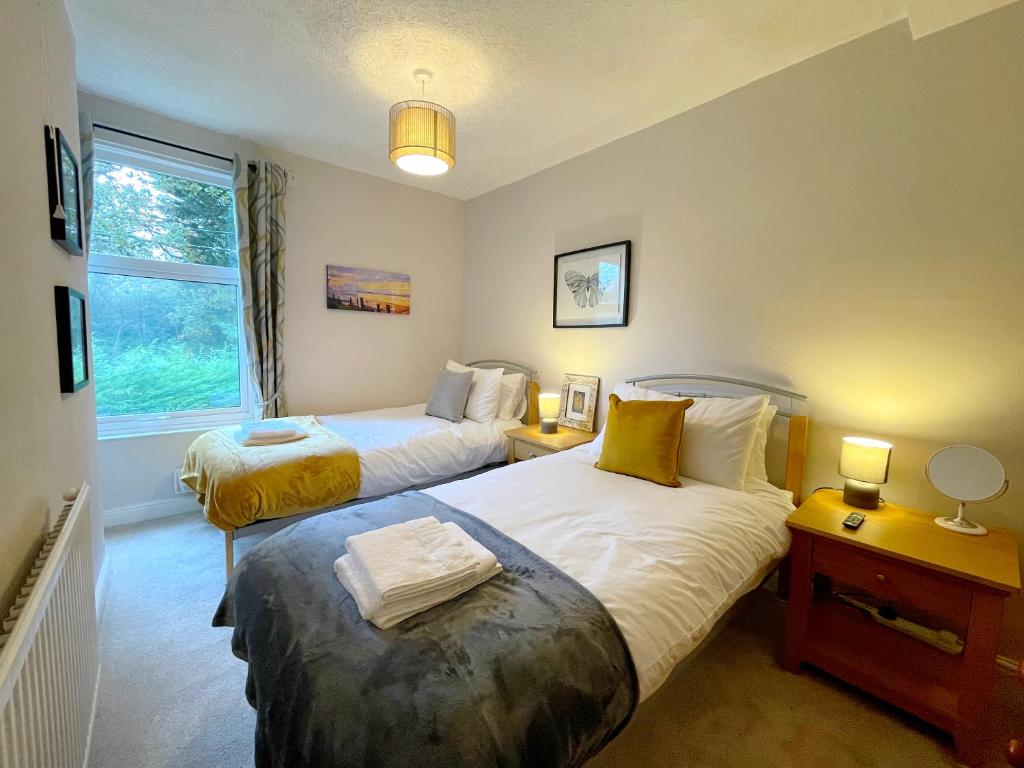 ein Schlafzimmer mit zwei Betten und einem Fenster in der Unterkunft Stylish cottage in vibrant riverside village in North Ferriby