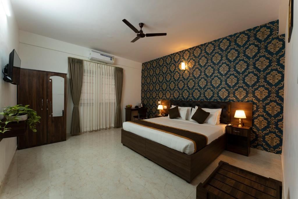 a hotel room with a bed and a wall at Sai Bliss Residency, Manyata Tech Park in Bengaluru