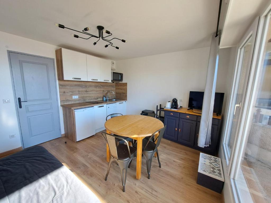 a small kitchen with a wooden table in a room at Charmant studio Cabine au cœur de Font Romeu in Font Romeu Odeillo Via