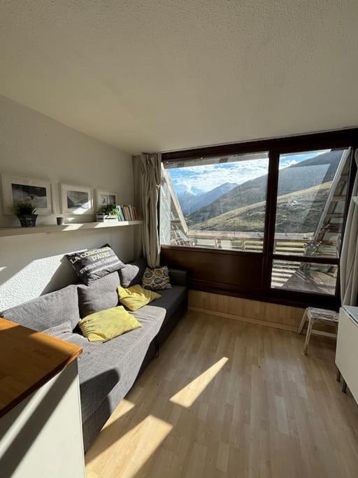 Cette chambre comprend un lit et une grande fenêtre. dans l'établissement Super studio à la résidence Cantoural, à Le Plan