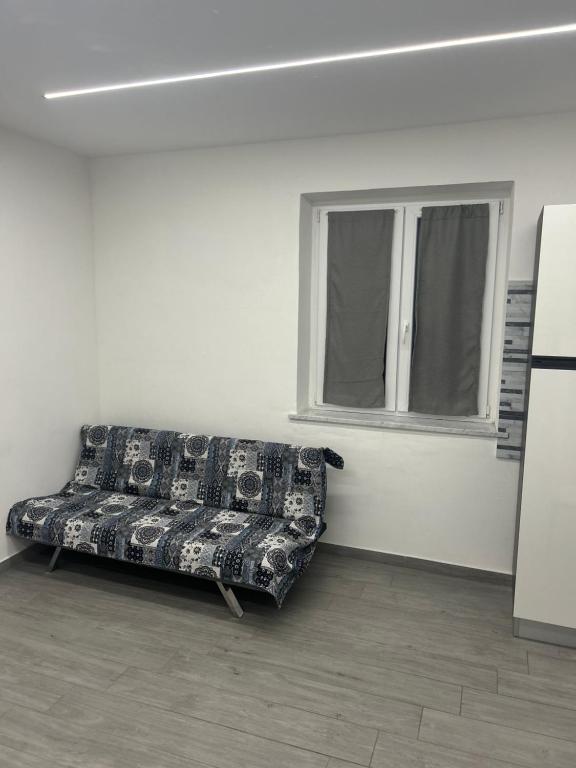 a couch sitting in a room with a window at Appartamento Tortona in Tortona