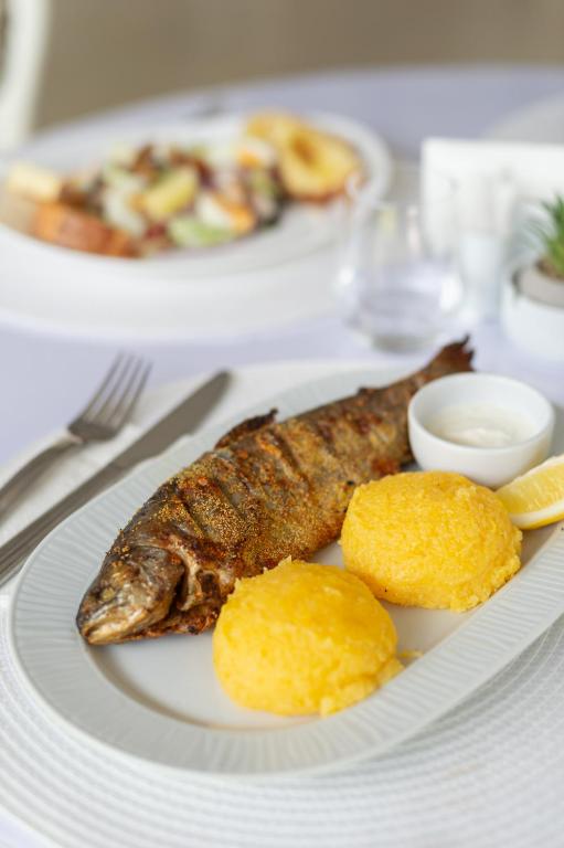 a plate of food with fish and biscuits on a table at Complex Pescăresc Gura Repezii Borșa in Borşa