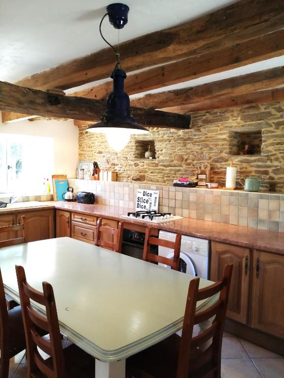 - une cuisine avec une table blanche et un comptoir dans l'établissement Clipgites, à Pleugriffet