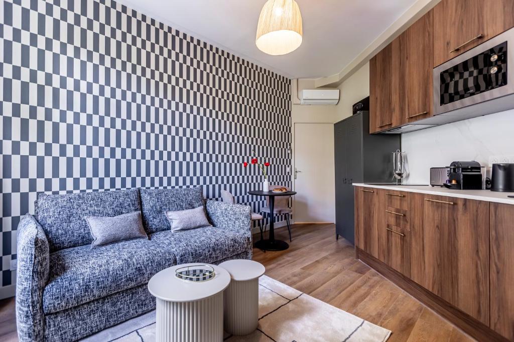 a living room with a couch and a kitchen at Résidence LeVilliers in Paris