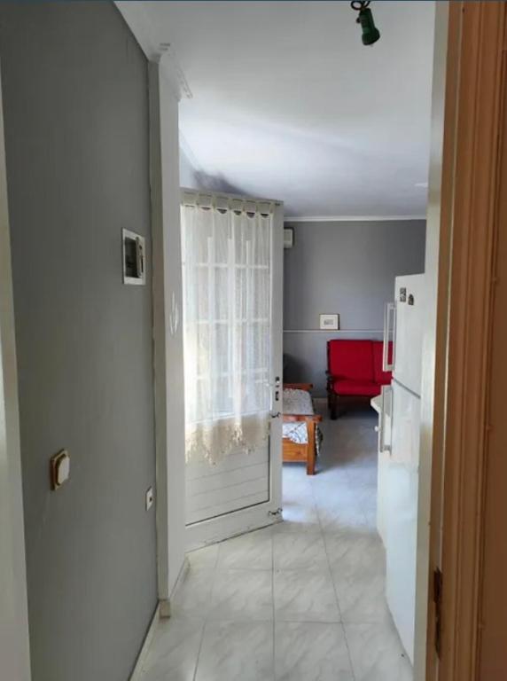 a hallway with a white door and a refrigerator at The Secret Garden Cottage in Mytilini