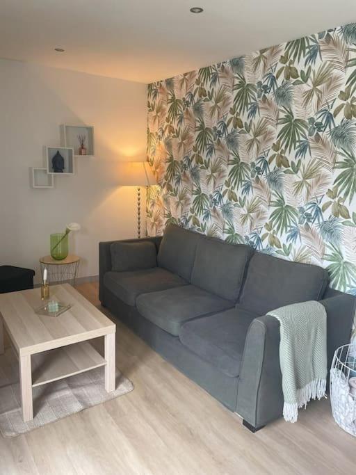 un salon avec un canapé bleu et une table dans l'établissement Maison chaleureuse bord de mer, à Plérin