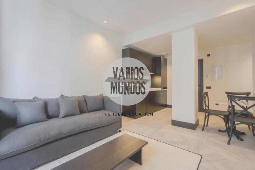 ein Wohnzimmer mit einer grauen Couch und einem Tisch in der Unterkunft Un Madrid histórico para 4, en Plaza del Carmen E2 in Madrid