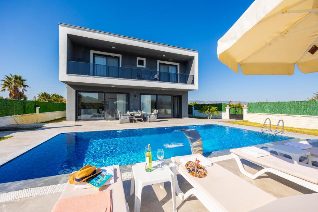 a villa with a swimming pool and a house at Villa Grand Yasar 2 in Okçular