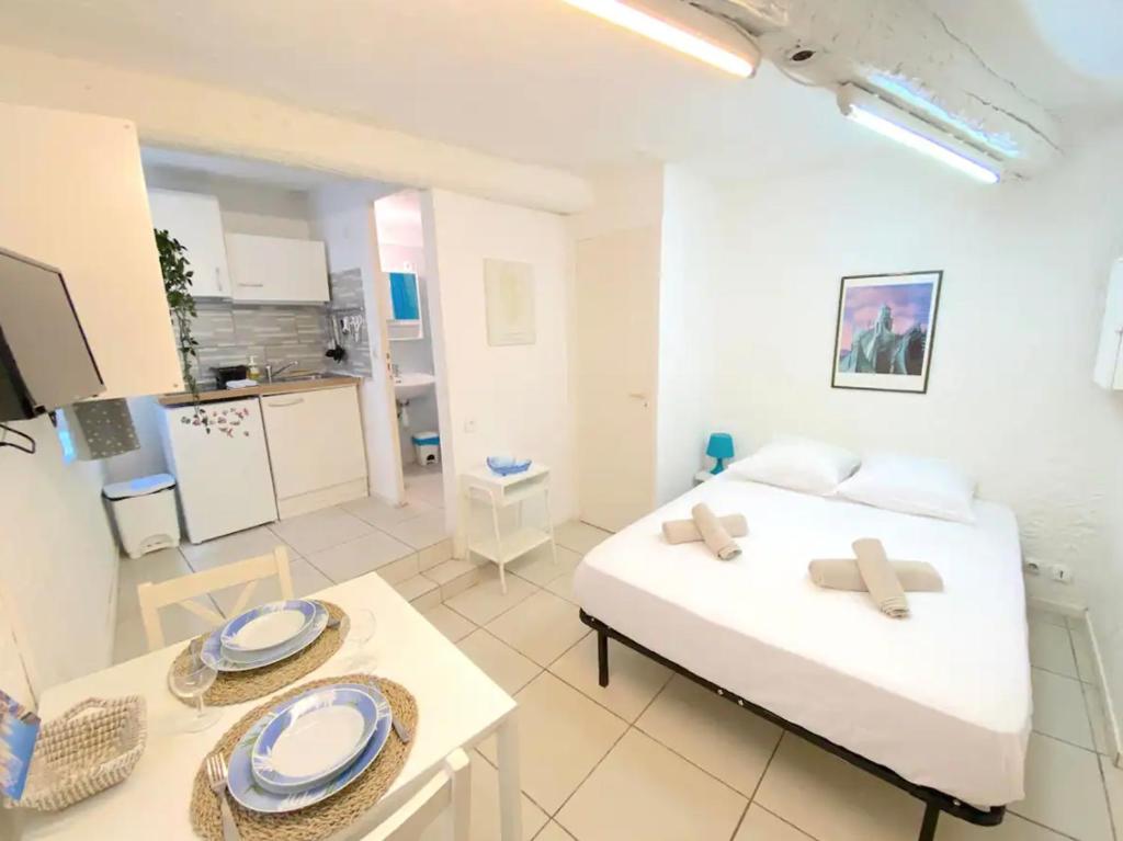 Cette chambre comprend un lit et une table avec des plaques de cuisson. dans l'établissement Studio au coeur de Toulon - proche du port, à Toulon