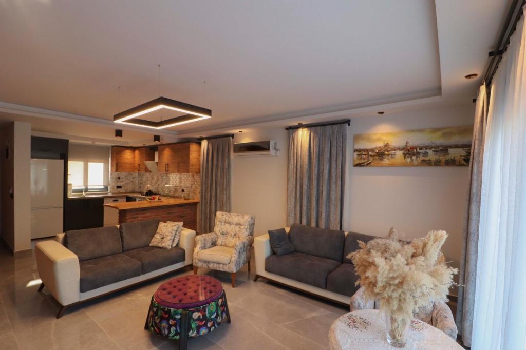 a living room with two couches and a kitchen at Adrasan Villa Adrasya in Olympos