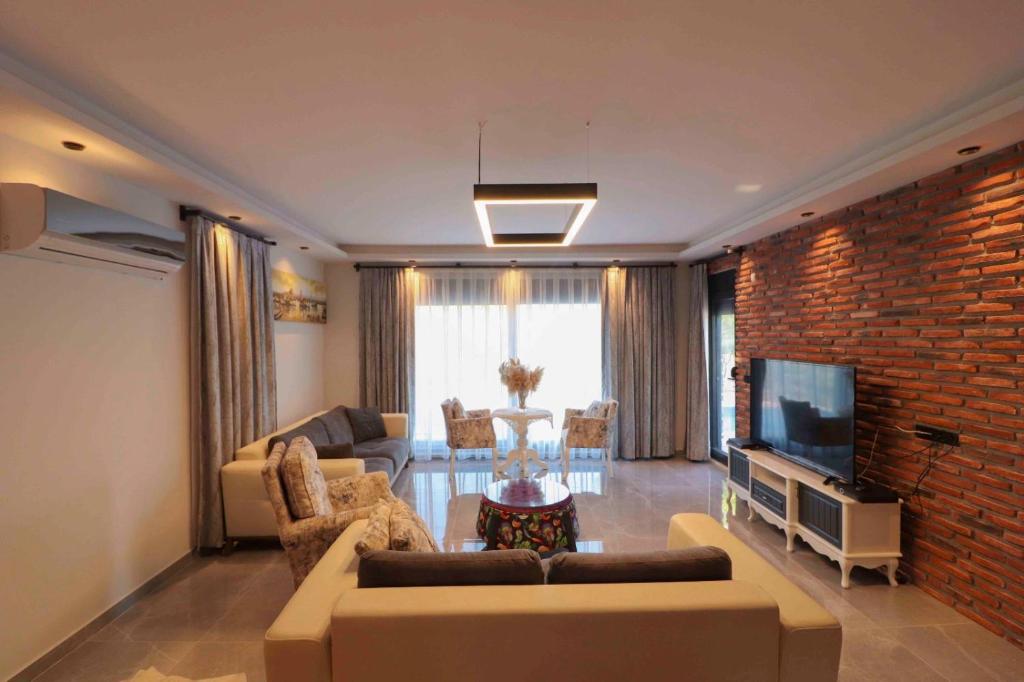 a living room with a couch and a brick wall at Adrasan Villa Adrasya in Olympos