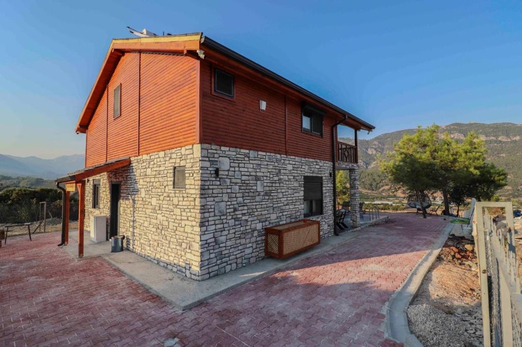 a large brick building with a roof at Adrasan Villa Adrasya in Olympos