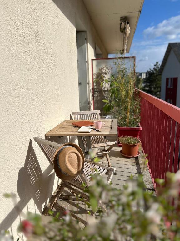 une table de pique-nique et des chaises sur un balcon avec des plantes dans l'établissement Le Serenity - lit XL, Parking, Proche Centre, à Rodez