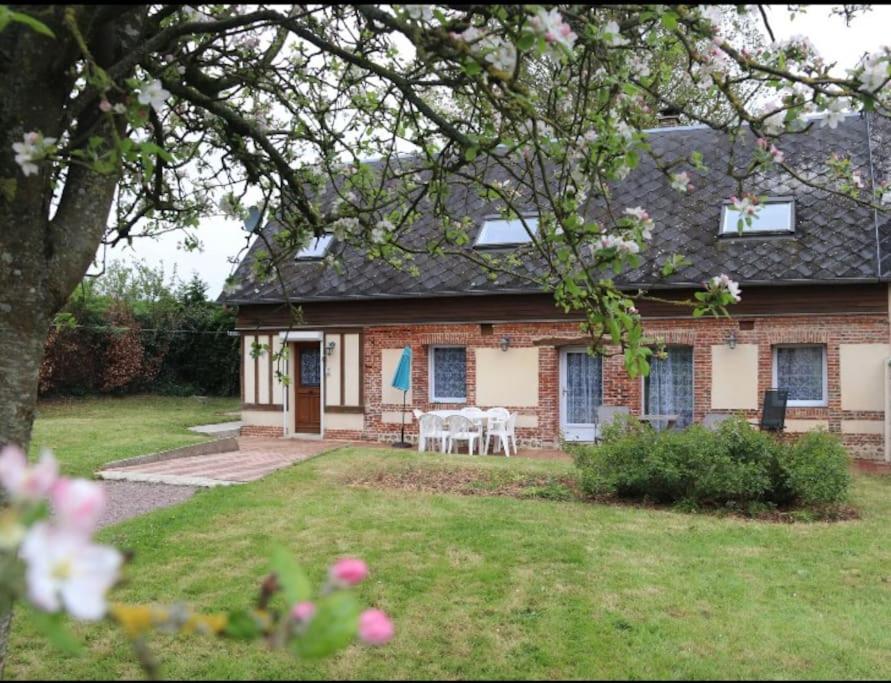 une maison en briques avec une table et des chaises dans la cour dans l'établissement Longère normande en Pays de Caux, à Grainville-la-Teinturière