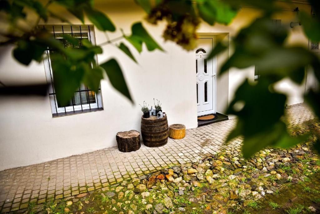 a white building with a door and two logs at CLAS Studio in Sibiu