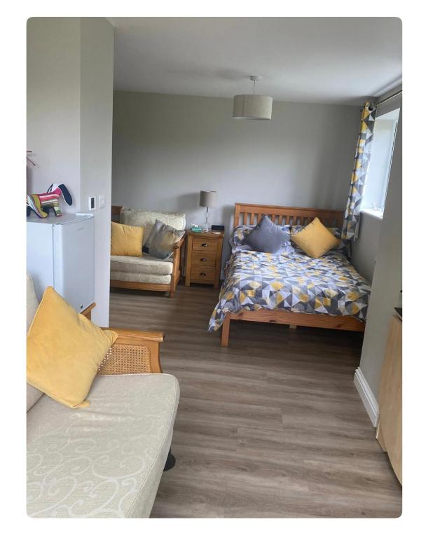 a living room with a bed and a couch at Chez Little Black Cat in Patrington