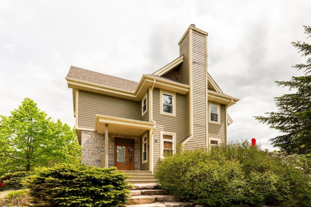 une maison avec une cheminée en haut dans l'établissement Mont Tremblant Bliss - Luxury Ski-Golf Retreat by Instant Suites, à Mont-Tremblant