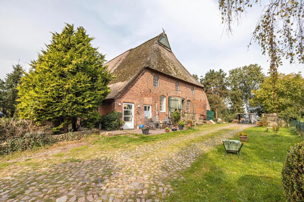 an old brick house with a thatched roof at De Olle Uhlhoff in Barlt