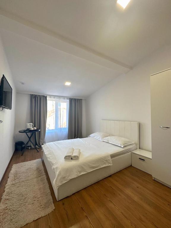 Un dormitorio con una cama blanca grande y una ventana en Residence Ultracentral Brasov, en Brasov