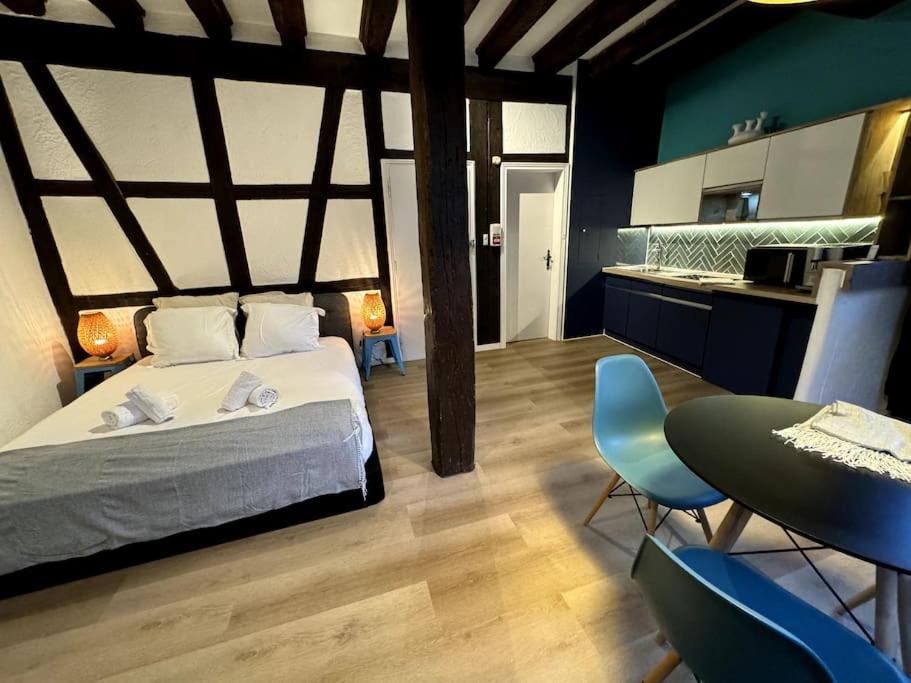 une chambre avec un lit, une table et des chaises dans l'établissement Suite Schwendi - Le petit tanneur - en Hypercentre, à Colmar