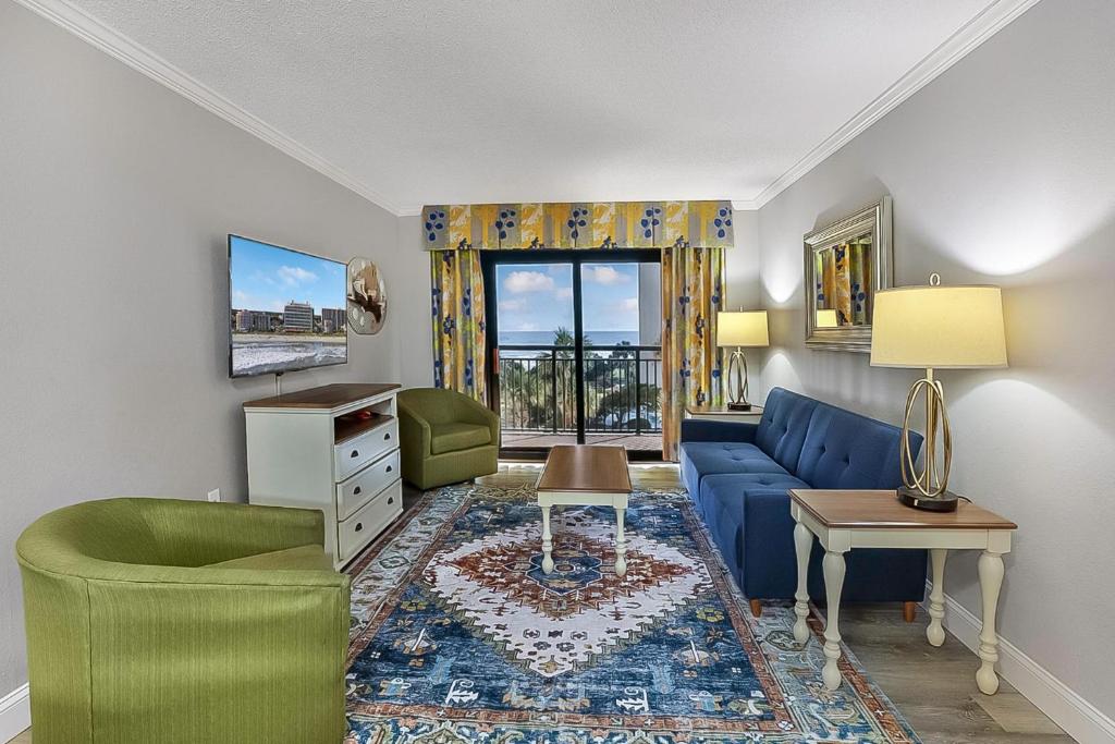 a living room with a blue couch and a table at Seas the View at Ocean Reef Resort #320 in Myrtle Beach