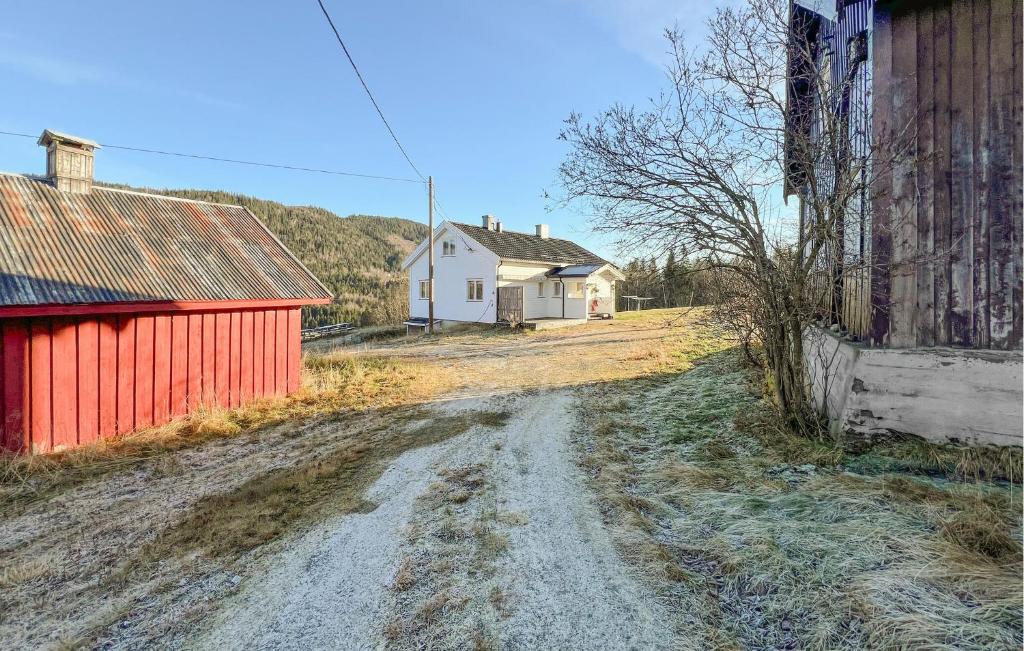ein Feldweg neben einem weißen Haus und einem roten Gebäude in der Unterkunft Beautiful Home In Vestre Gausdal in Vestre Gausdal