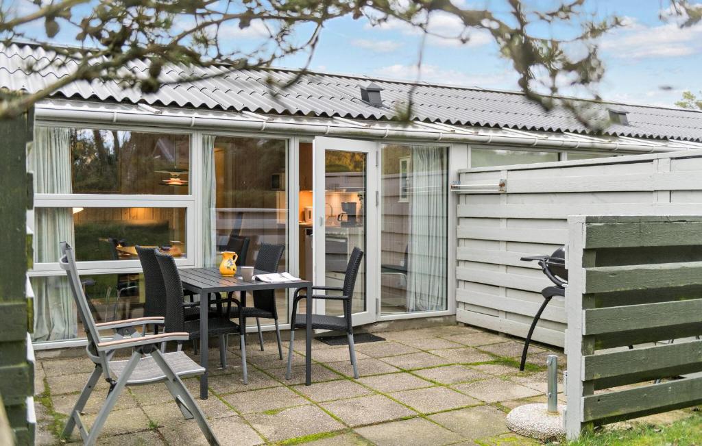 a screened in patio with a table and chairs at Stunning Apartment In Vejers Strand in Vejers Strand